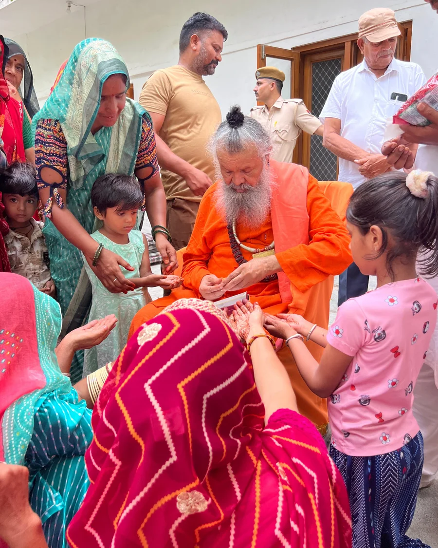 Gurudev distributing sweets to happy children.